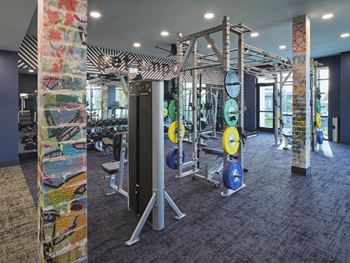 a gym with weights and cardio equipment in a building